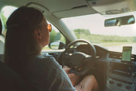 Woman driving a car in summer time.の写真素材