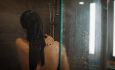 Woman washing herself in the shower.の写真素材
