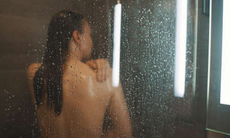 Woman washing herself in the shower.の写真素材