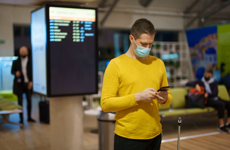 Man is waiting for his flight at the airport.