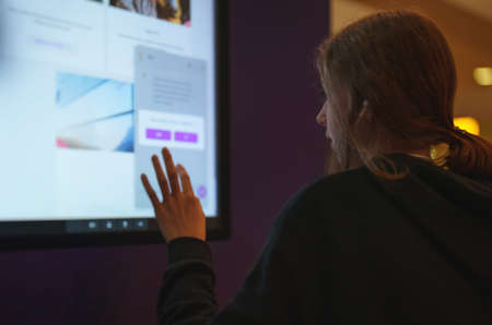 Teenage girl using touch screen display.の写真素材