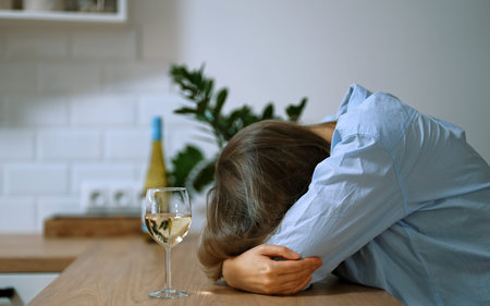 Woman suffering from depression and drinking alcohol.
