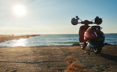 Red vintage scooter on the seashore.