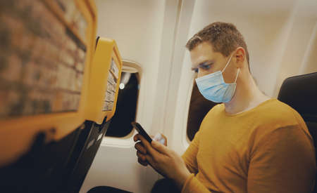Man with smartphone inside the airplane.の写真素材