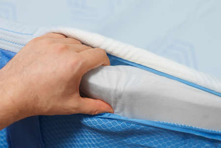 Man hand testing memory foam mattress topper.の写真素材
