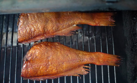 Smoked perch fish in smokehouse on the grate.