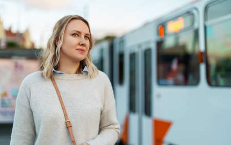 Pretty woman stands at a tram stop.の写真素材