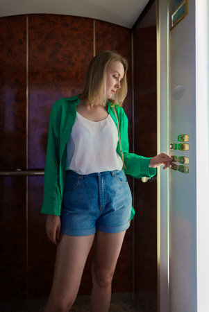 Woman pressing button inside the elevator.