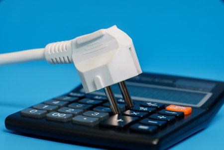 Electricity growth concept. Calculator and AC power plug.の写真素材