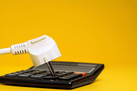 Electricity growth concept. Calculator and AC power plug.の写真素材
