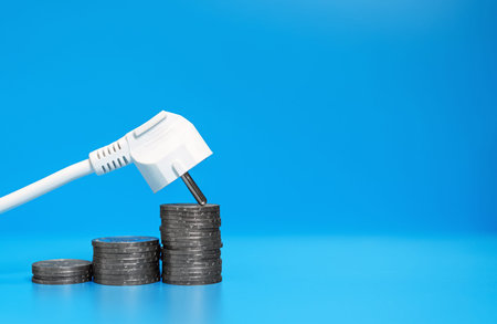 Concept of rising electricity prices. AC power plug and coins.