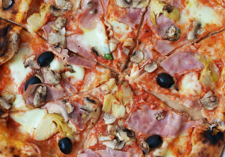 Pizza capricciosa. Pizza with ham, olives, mushrooms and artichokes.の写真素材