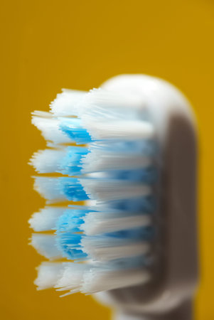 Electric ultrasonic toothbrush bristles on yellow background.の写真素材