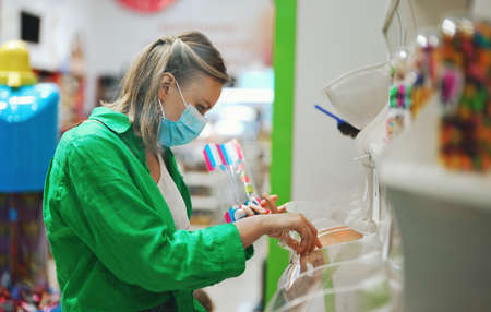 Woman in a medical mask buys candys.の写真素材