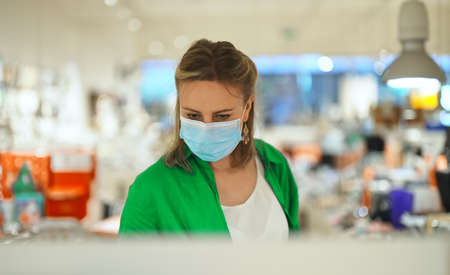 Woman in medical mask chooses a gift in toy store.の写真素材