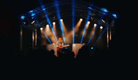Singer with guitar performing on stage at evening.の写真素材