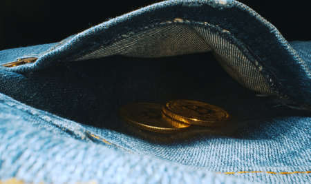 Golden bitcoin in the back pocket of jeans.の写真素材