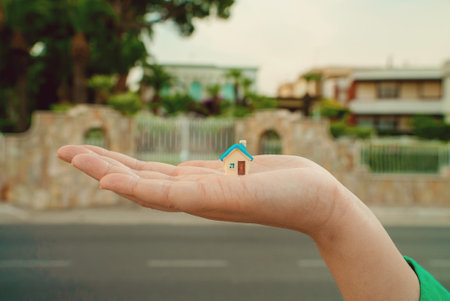 House toy on a woman's palm. Real estate purchase concept.の写真素材