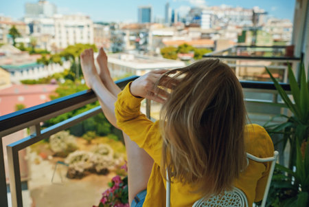 Woman enjoys her vacations on the balcony.の写真素材