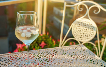 Glass of white wine on the balcony at sunset.の写真素材