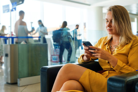 Woman is waiting for her flight at the airport.の写真素材