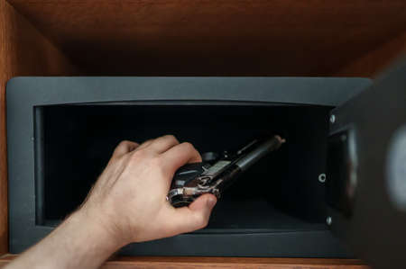 Man puts the weapon in the safe.の写真素材
