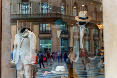 Men mannequins advertise summer clothes behind glass.の写真素材