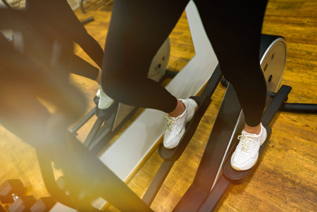 Woman training on elliptical trainer in gym