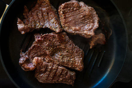 Beef steak with pepper is fried in a pan.の写真素材