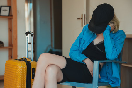 Teenage girl got ready before everyone else and is waiting to go on vacation.の写真素材