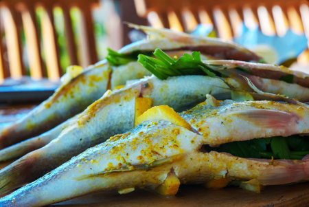 Dorado fish with lemon and spices prepared for grill.