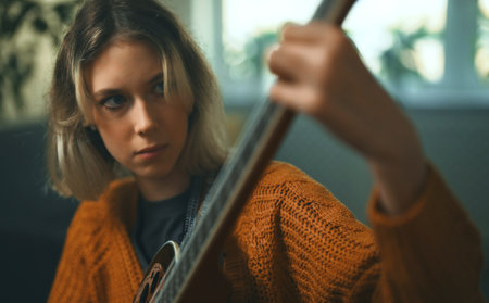 Teenage girl learning to play acoustic guitar.の写真素材