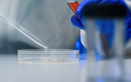 Scientist working with test tubes and petri dish in lab.の写真素材