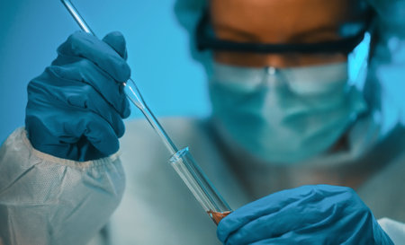 Woman in goggles and mask working with test tubes in laboratory.の写真素材
