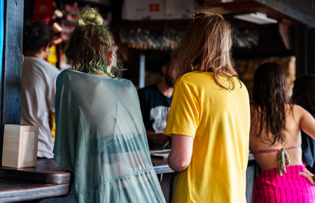 Two women order cocktails at a beach bar.の写真素材
