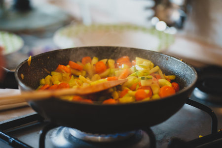 Zucchini with carrots and onions frying in pan.