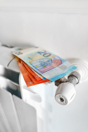 Concept of expensive heating payments. Money on the radiator.の写真素材
