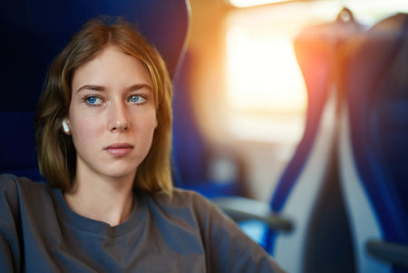 Teenage girl with earphones travelling inside the train.の写真素材