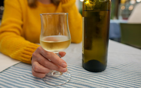 Woman drinks white homemade wine in a restaurant.の写真素材