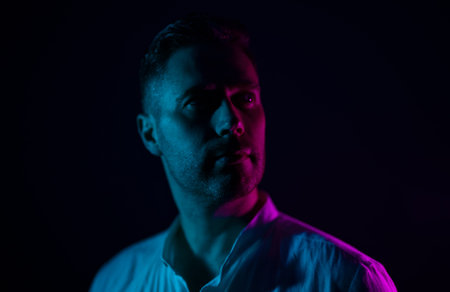 Portrait of a handsome unshaven middle-aged man. In neon light.の写真素材