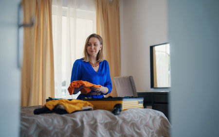 Woman is packing clothes into suitcase. Getting ready for the trip.の写真素材