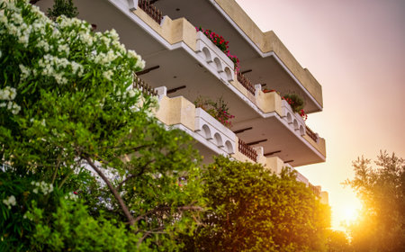 Apartment building with greenery on the sunset.の写真素材