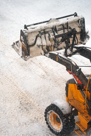 Tractor shoveling snow on the street.