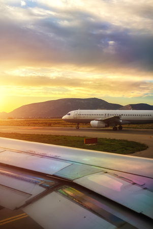 Commercial plane prepares to take off at sunset.の写真素材