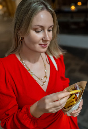 Woman eats pita with french fries.