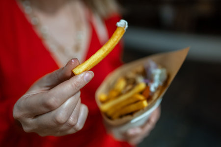 Woman eats pita with french fries.