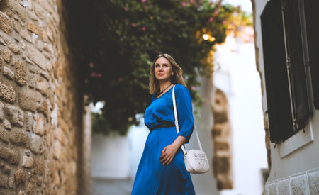 Female tourist in a blue dress on the street of Lindos in Greece.の写真素材
