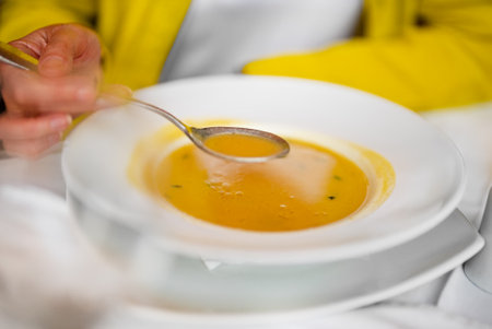 A woman eats puree soup in a restaurant.の写真素材