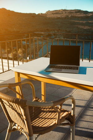 Laptop on the table on the balcony. Freelancing and remote work concept.