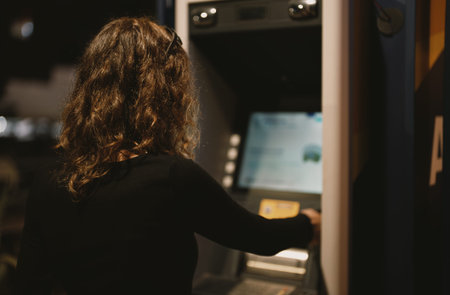 Girl using ATM on the street.